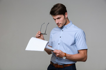 Concentrated business man holding clipboard.