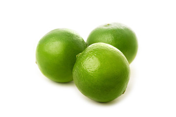 Three fresh whole limes isolated on white background. Side view