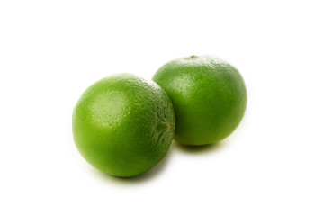 Two fresh whole limes isolated on white background