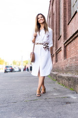 Happy young business woman walking on the street.