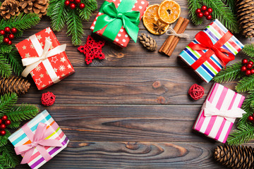 Top view of Christmas background made of fir tree, gifts and other decorations on wooden background. New year holiday concept with copy space