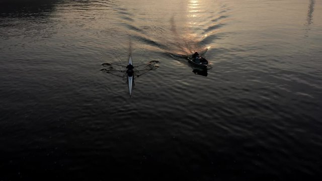 Aerial view of a kayak regatta, a group of two people rowing on oars along the river.  Athletes rowers train on oars with a coach, training takes place on a foggy morning at sunrise. Warsaw, Poland.