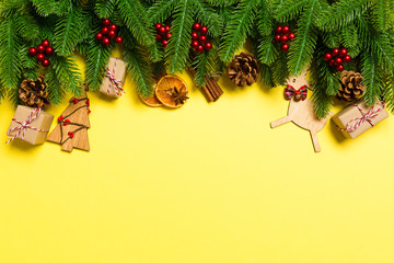 Top view of Christmas decorations on yellow background. New Year holiday concept with copy space