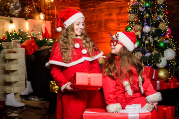 Obraz na płótnie Canvas Cute girls sisters friends celebrate christmas at home. Waiting for Santa claus. Have fun. Children join christmas carnival party. Be Jolly and make good cheer for Christmas comes but once a year