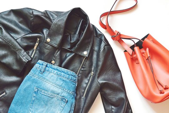 Black Faux Leather Biker Jacket, Trendy Blue Jeans And Stylish Red Bag Flat Lay Photography. 90s Fashion Style
