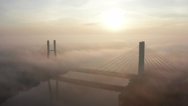 Siekierkowski Bridge, Warsaw, Poland.  Aerial view of the sost with the movement of cars across the Vistula River.  Foggy morning, sunrise and a beautiful view of the city infrastructure.