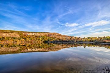 Fall foliage colors reflected in still lake water on a beautiful autumn day