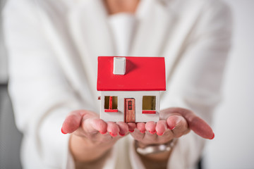 partial view of businesswoman showing house model