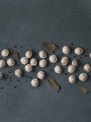 Fototapeta na wymiar Pattern of frozen uncooked russian pelmeni with peppercorns and bay leaves on black background. Creative layout of dumplings. Beautiful scattered raw dumplings. Top view, flat lay. Copy space for text