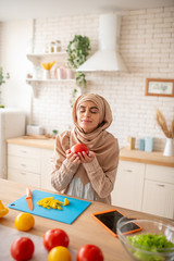 Pretty woman enjoying the smell of vegetables