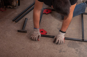 Measurement and welding tool. The worker welds a metal structure.