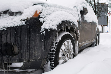 wheels of a black car in deep snow.