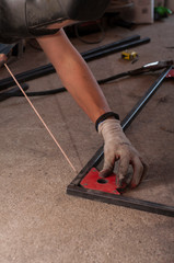 Measurement and welding tool. The worker welds a metal structure.