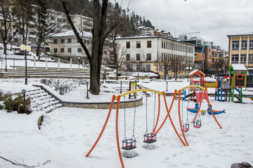 Wintertime in the city Smolyan, empty children playground, toys covered in snow, playground covered in snow, sport units