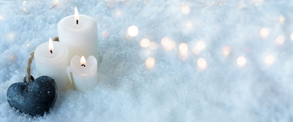 Candles with a heart in snow