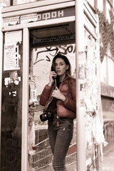Obraz premium Young woman calling in a phone cabin.
