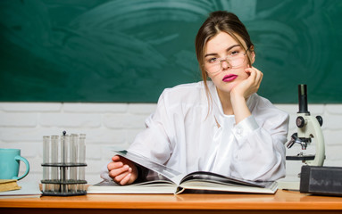 Fototapeta premium Study hard. Education concept. Woman pretty adorable teacher or student. Biology student sit classroom chalkboard background. Scientific research. Chemist biologist with microscope. Smart student
