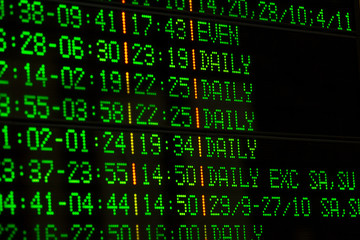 Electronic departures and arrivals board with green and red symbols