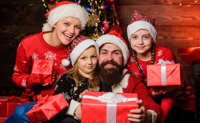 Fototapeta na wymiar Christmas joy. Christmas tradition. Happy holidays. Parents and children opening christmas gifts. Cheerful family concept. Father Santa claus and mother little daughters christmas tree background