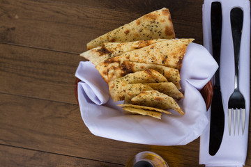 Costini. Seasoned baked pasta. Fork and knife on a white napkin. Food served as an aperitif in...
