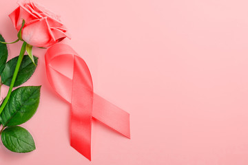 red ribbon and rose on a pink background. 1 December World AIDS Day, HIV illness campaign.