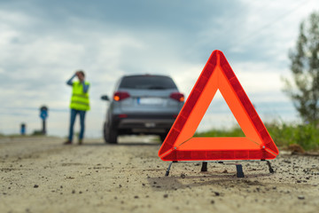 Vehicle breakdown and warning triangle on the road