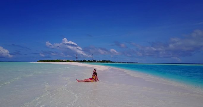 Couple who has just come on vacation enjoying their first day in The Maldives, sitting on white sand beach - Powered by Adobe