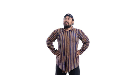 asian man with javanese traditional cloth lurik looking up while hand on hips