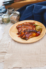 Chinese lacquered pork slices with its caramelized sauce prepared for eating in a wooden plate