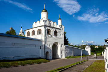 Fototapeta na wymiar Russia, Vladimir Oblast, Golden Ring, Suzdal: White wall and entrance gate to the old famous Intercession Monastery (Pokrovsky and Blagoveshchenskaya) in one of the oldest Russian towns - religion