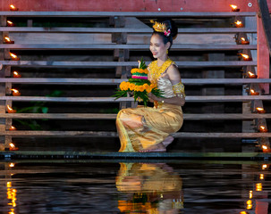 Beautiful woman in Thai traditional costume making Loy Kratong festival of Thailand.