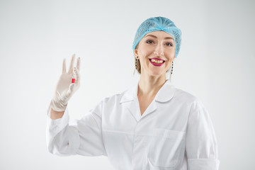 Silhouette of a doctor anesthetist with a syringe on a gray background.