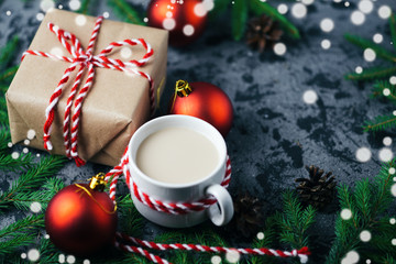 Hot morning coffee and Christmas gift on the table with tree branches
