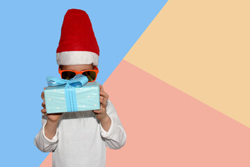 boy with a white beard in a suit of santa claus or elf holds a gift in his hand, concept christmas