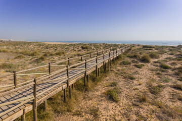 Fototapeta na wymiar Footbridge on the sand dunes in the Mediterranean, spain