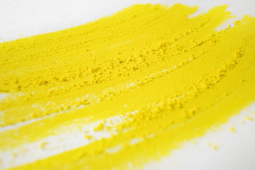 Strokes of yellow dry pastel and crumbs on white paper. Texture abstract background. Macro photo. Concept drawing, art.