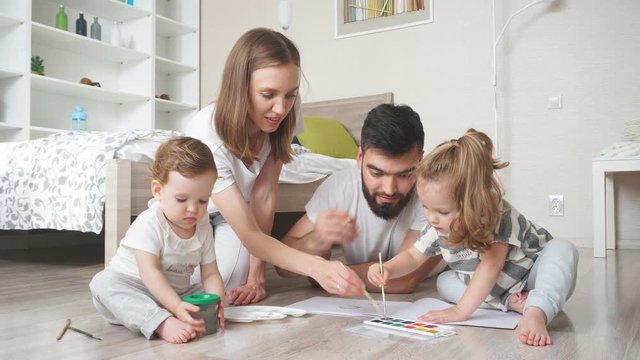 Young parents spending tim with their children, they helping them to do homework.