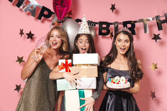 Image of party girls celebrating birthday with gift boxes and sweet cake