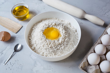 flour rolling pin and eggs on concrete background preparation for baking