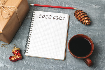 2020 goals, text on the paper in notepad, New Year promises concept, gift box, coffee cup, decorations