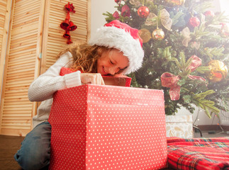 Obraz na płótnie Canvas Child with gift near christmas tree