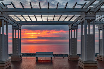 lever de soleil au travers d'une pergola  sur la Promenade des anglais et la baie des anges à Nice