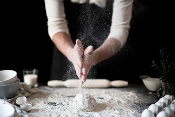 Cotton with male hands, flour scatters, prepares ecologically natural pastries