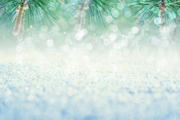 Winter abstract, blurred background with bokeh. Sparkling snow in the sun, blurry lights, pine branches