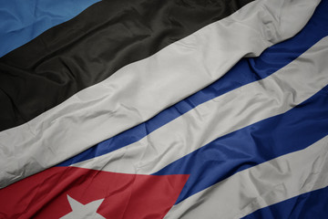 waving colorful flag of cuba and national flag of estonia.