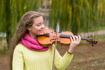 Young violinist playing in the park