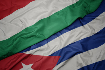 waving colorful flag of cuba and national flag of hungary.