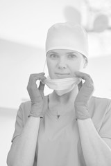 Portrait of female doctor removing surgical mask at clinic
