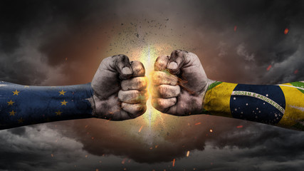 EU vs EU. Fists with flags. Battle EU with Brazil on sky.