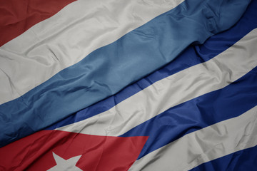 waving colorful flag of cuba and national flag of luxembourg.